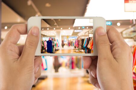 Taking a picture with a smart phone in shopping mall.の写真素材