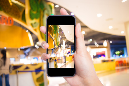 Taking a picture with a smart phone in shopping mall.