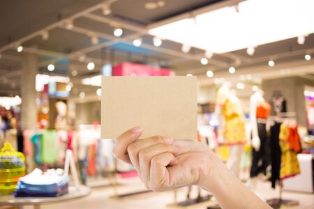 Photo blank. Hand hold blank business card in the shopping mall.の写真素材
