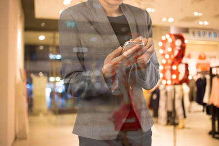 Businesswoman using smart phone in shopping mall.