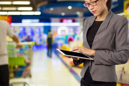 Woman using tablet in shopping mall.