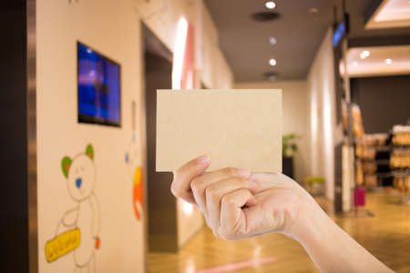 Photo blank. Hand hold blank business card in the shopping mall.の写真素材