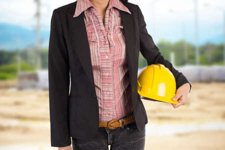 Engineer holding yellow helmet for workers security on backgroundの写真素材