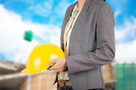 Engineer holding yellow helmet for workers security on backgroundの写真素材