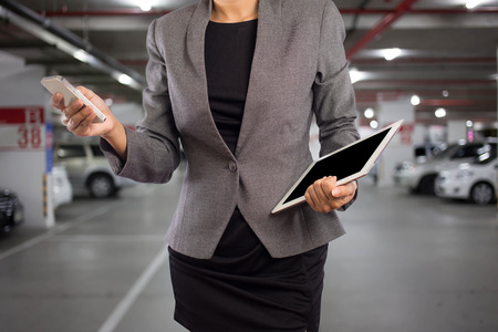 Businesswoman in Underground parking with cars.の写真素材