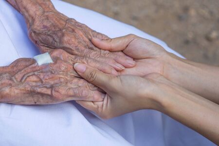 Old and young holding hands.の写真素材