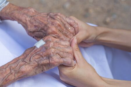 Old and young holding hands.の写真素材