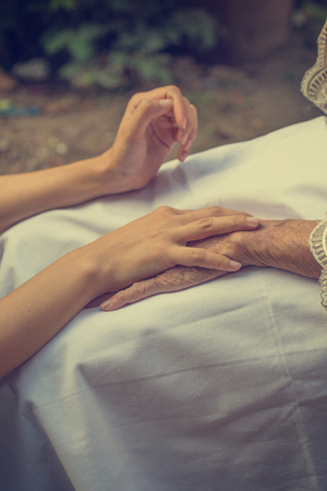 Old and young holding hands.の写真素材