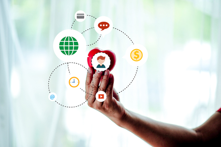 Adult Mobile Holds Red Heart, Health Care, Donation and Family Insurance Concepts, World Heart Day, World Health Day, Social Responsibility Concept Love on Valentines Dayの写真素材