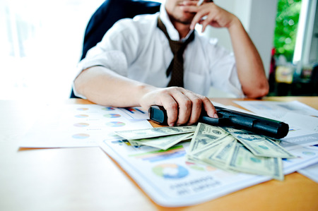 Businessmen with money in hand, US dollars, investment, success and profitable business ideas. Businessman with a firearm.の写真素材