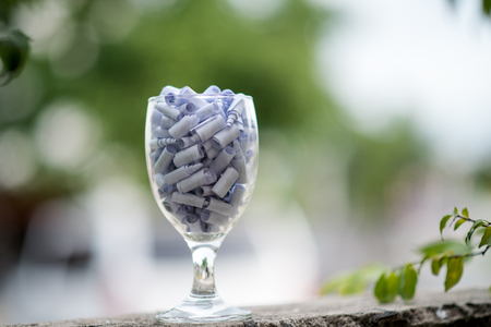 A glass of clear wine with white paper inside the concept of filling the good things into a glass of clear one.の写真素材