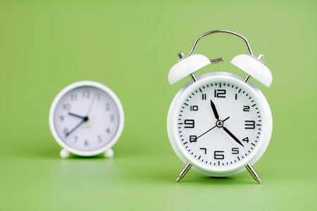 White clock on light green background, concept of time Time planningの写真素材