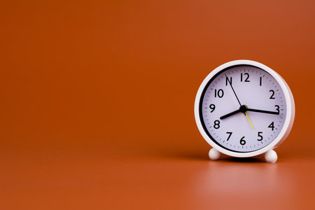 White clock on brown background, time concept working with time Planning time for lifeの写真素材