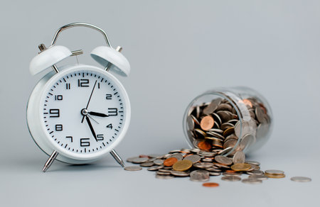 Coins and an alarm clock savings concept finance finance business