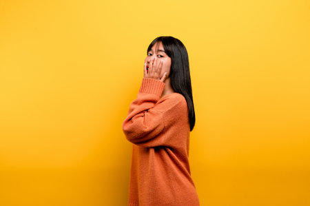 Cute Asian girl smiling on yellow background. Empty, young woman. Place for advertisement. copy spaceの写真素材