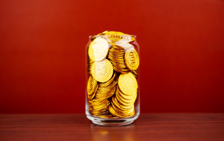gold coins in a glass jar saving money coin coin bank income wages expenditure money financial...