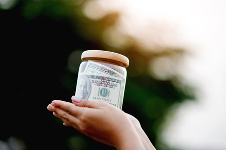 dollar bills in glass bottles Saving money in a glass jar, earnings, income, expenses, profits,...