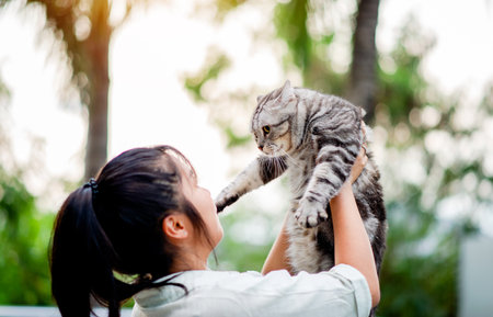 Woman holding cat playing at home with love for cats The smile glints in his bond with his fluffy...