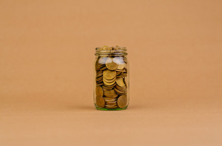Saving coins in a glass jar Saving money for the future, investment savings, salary, income, expenditure, financial loan, home loan, loan, savings and financial growth concept.の写真素材