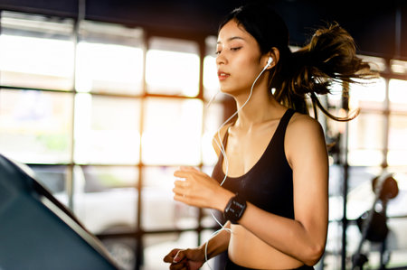 Jogging with a treadmill working out in the gym joy of running listen to music while running young...