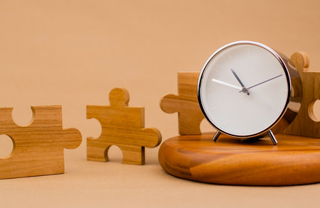 Clock and jigsaw puzzle pieces. Time lapse time. Wooden jigsaw puzzle pieces. communication teamwork key componentsの写真素材