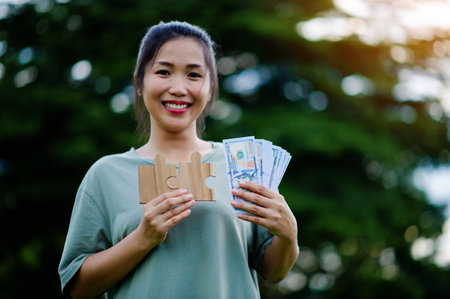 Dollar in the hands of an Asian woman Savings, Investments, Salary, Income, Cash Flow, Happiness and...