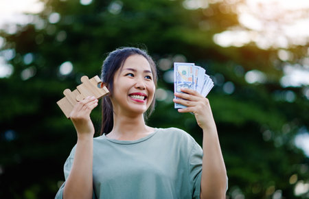 Dollar in the hands of an Asian woman Savings, Investments, Salary, Income, Cash Flow, Happiness and Financial Success and Investments.の写真素材