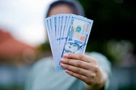 Dollar in the hands of an Asian woman Savings, Investments, Salary, Income, Cash Flow, Happiness and...