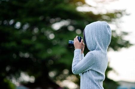 Take pictures with a mirrorless camera. Little girl practicing nature photography little photographer the joy of taking picturesの写真素材