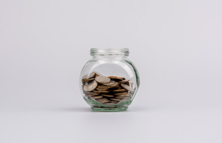 Saving coins in a glass jar Banking Finance Concepts of saving money, income, wages, cash flow, investments, mutual funds, financial taxes. financial loansの写真素材