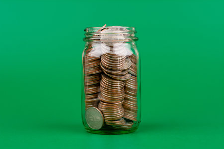 Saving coins in a glass jar money saving concept Finance and banking, mutual funds, cash, cash flow, income, wages, investments, financial growth and investment.の写真素材