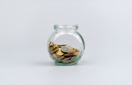 Saving coins in a glass jar Finance and financial investment, cash flow, income, wages, Thai bahtの写真素材