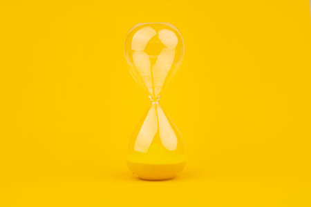 Hourglass on yellow background, time and countdown time limit for urgent work to meet deadlines and...