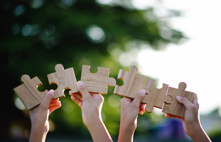 Wooden jigsaw puzzle, cooperation and teamwork, unity among groups and inspiration for good work.の写真素材