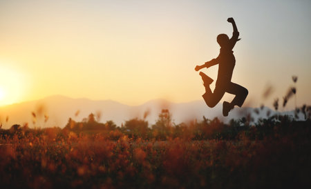 Silhouette of happiness and being free and relaxed in living life, success and working towards planned life goals.の写真素材