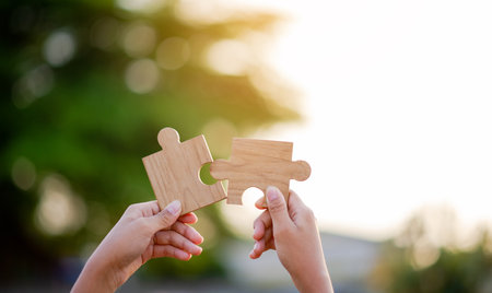 Wooden jigsaw puzzle Teamwork and cooperation, unity among colleagues, is a sign of growth and success.の写真素材