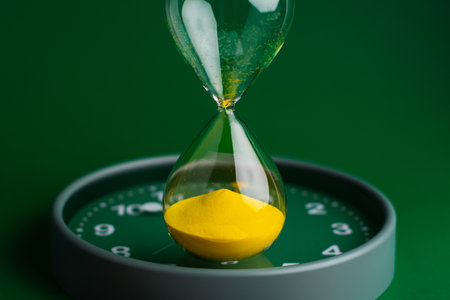 Hourglass stops time of work and life. Process and rules of limited time. Hourglass photo in studio.