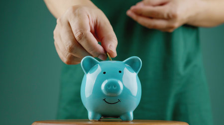 Saving coins in a piggy bank and financial planning, accumulating wealth for investment and retirementの写真素材