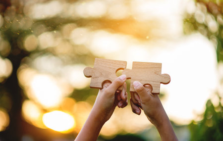 Cooperation in teamwork, expression through the use of wooden jigsaw puzzles, unity and teamwork.の写真素材