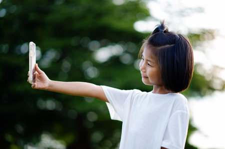 Social media communication for Asian girls who are enjoying exploring the world of technology on their own.の写真素材