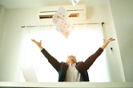 Successful business people throwing papers celebrating and enjoying their work, financial planning and investing, working on financial documents.の写真素材