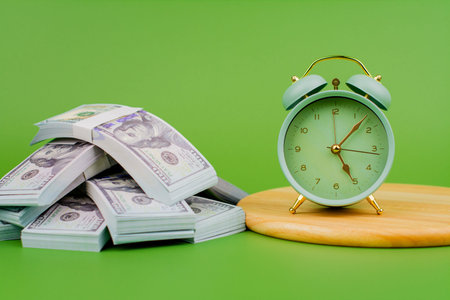 Dollars and working hours, financial well-being and financial goals, wealth, prosperity, financial growth and investment.の写真素材