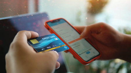 Credit cards and smartphones, online financial transactions, business travel planning, a close-up view of a credit card in hand.の写真素材