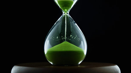 Green hourglass, an environmental concept. A green hourglass that is filling with sand.の写真素材