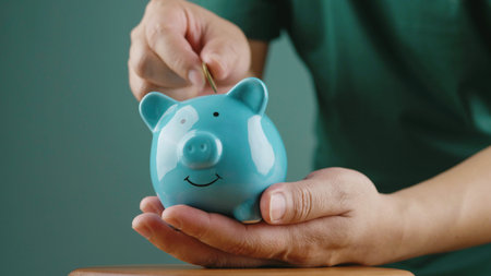 Saving coins in a piggy bank, financial planning, and investing for the future for financial growth.の写真素材