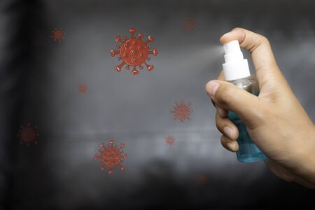 A woman's hand is cleaning sofa with an antiseptic spay as a means to prevent from corona COVID-19 and SARS cov 2 infection. Working from home.の写真素材