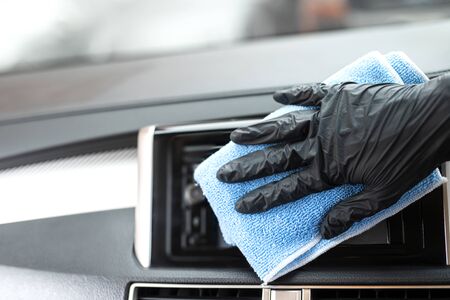 This image is a picture of wiping the car by a blue microfiber cloth with hand wearing gloves.Car...