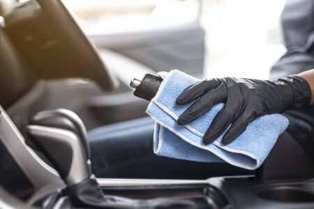 This image is a picture of wiping the car by a blue microfiber cloth with hand wearing gloves.Car...