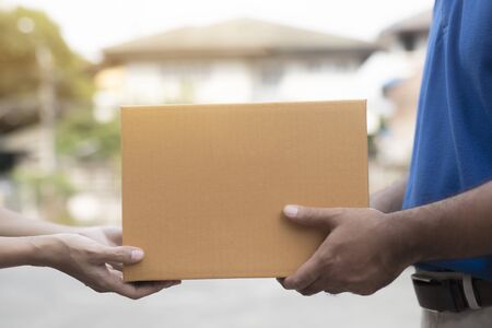 Woman hand accepting a delivery boxes of paper containers from deliveryman,Delivery concept.