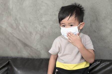 A boy wearing medical face mask for pollution or coronavirus,child itchy eyes and nose, Kid...